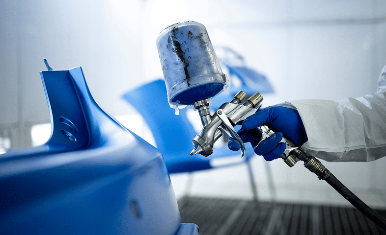 Blue car parts being spray painted