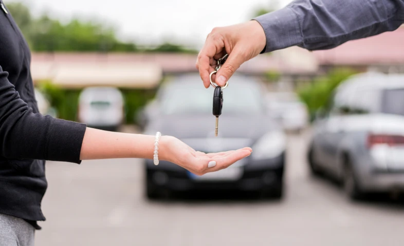 Handing over car keys in parking lot